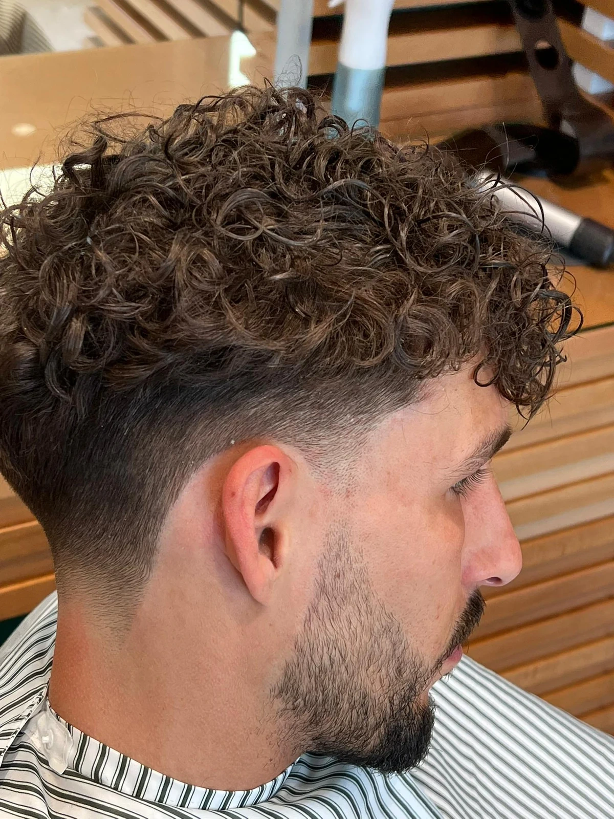 Curly fringe falling towards the forehead