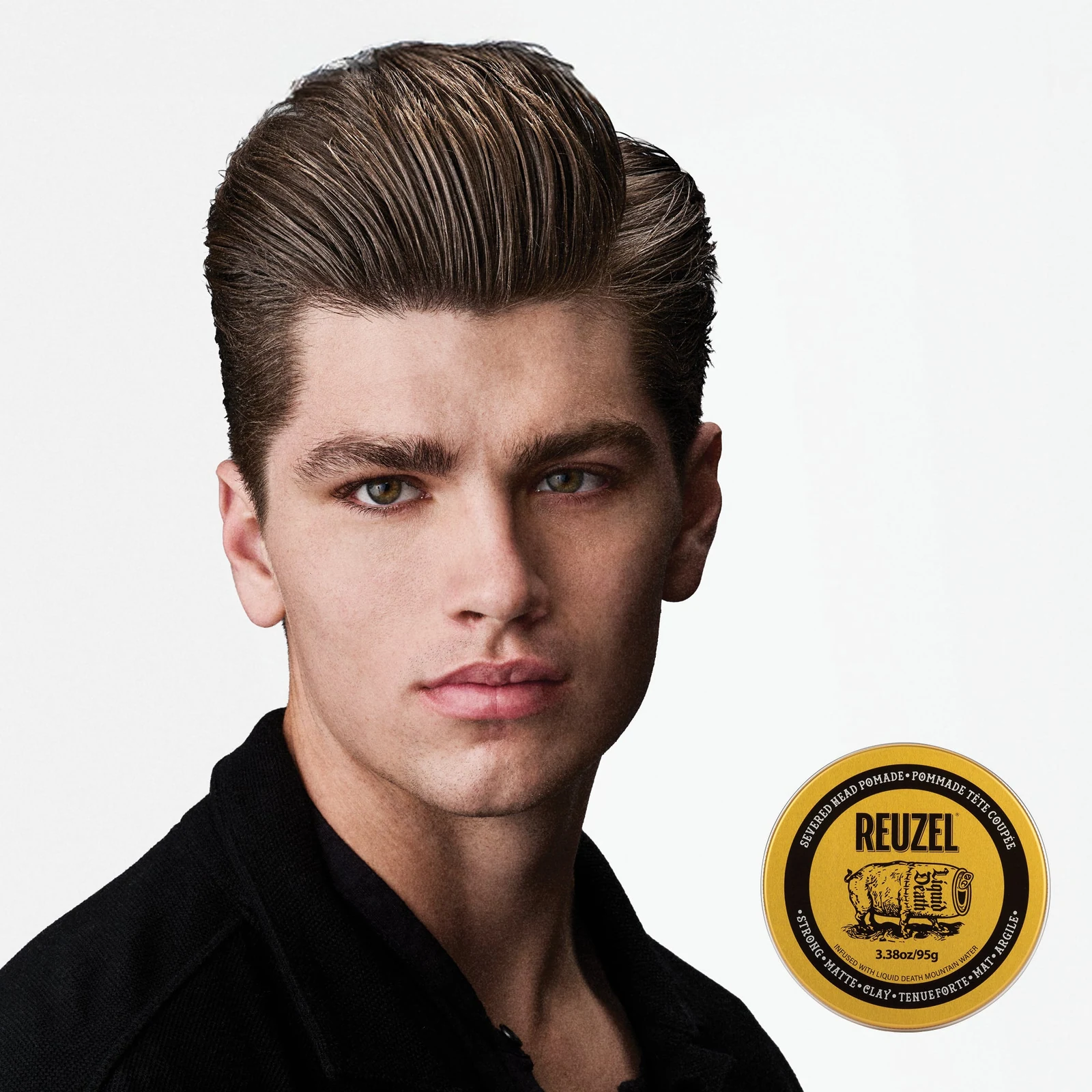 Reuzel - Strong Matte Clay - Liquid Death: Man with styled hair next to a puck of REUZEL x Liquid Death Severed Head Strong Matte Clay Pomad on a white bac