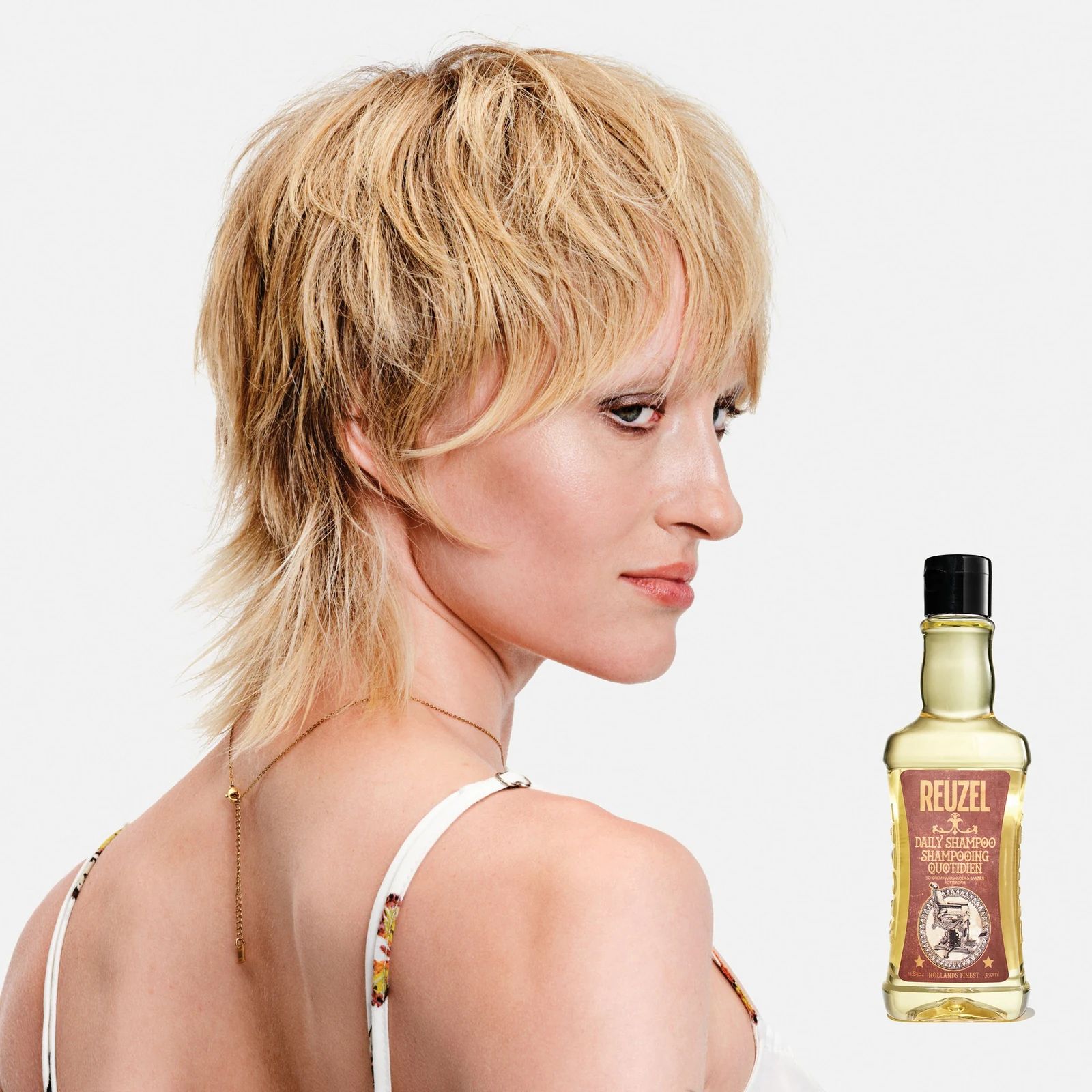 Reuzelinc daily shampoo bottle with label, close-up of the shampoo product on a plain background., view 6