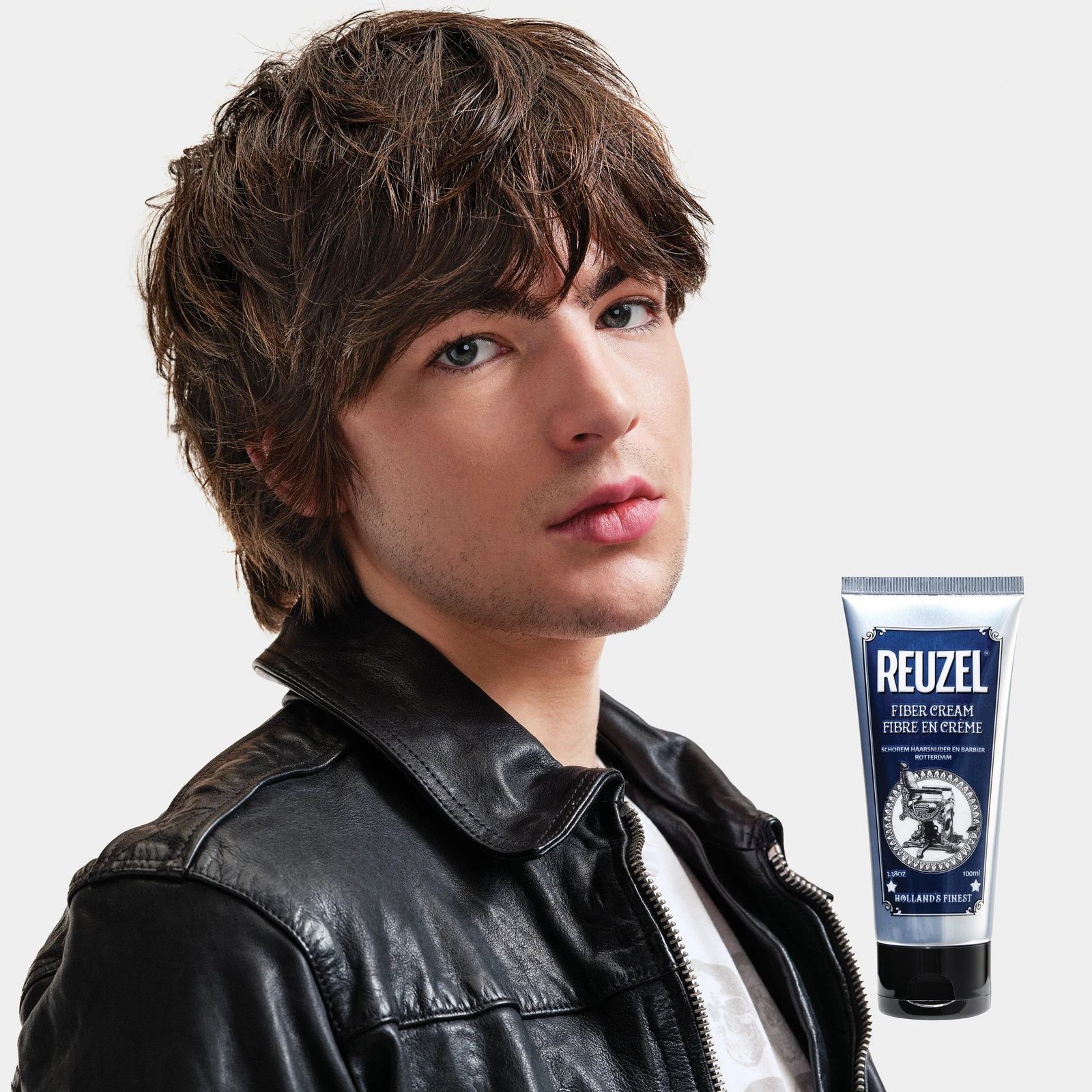 Reuzelinc Fiber Cream jar with textured label showing, used for styling and thickening hair, in a professional salon setting, view 9
