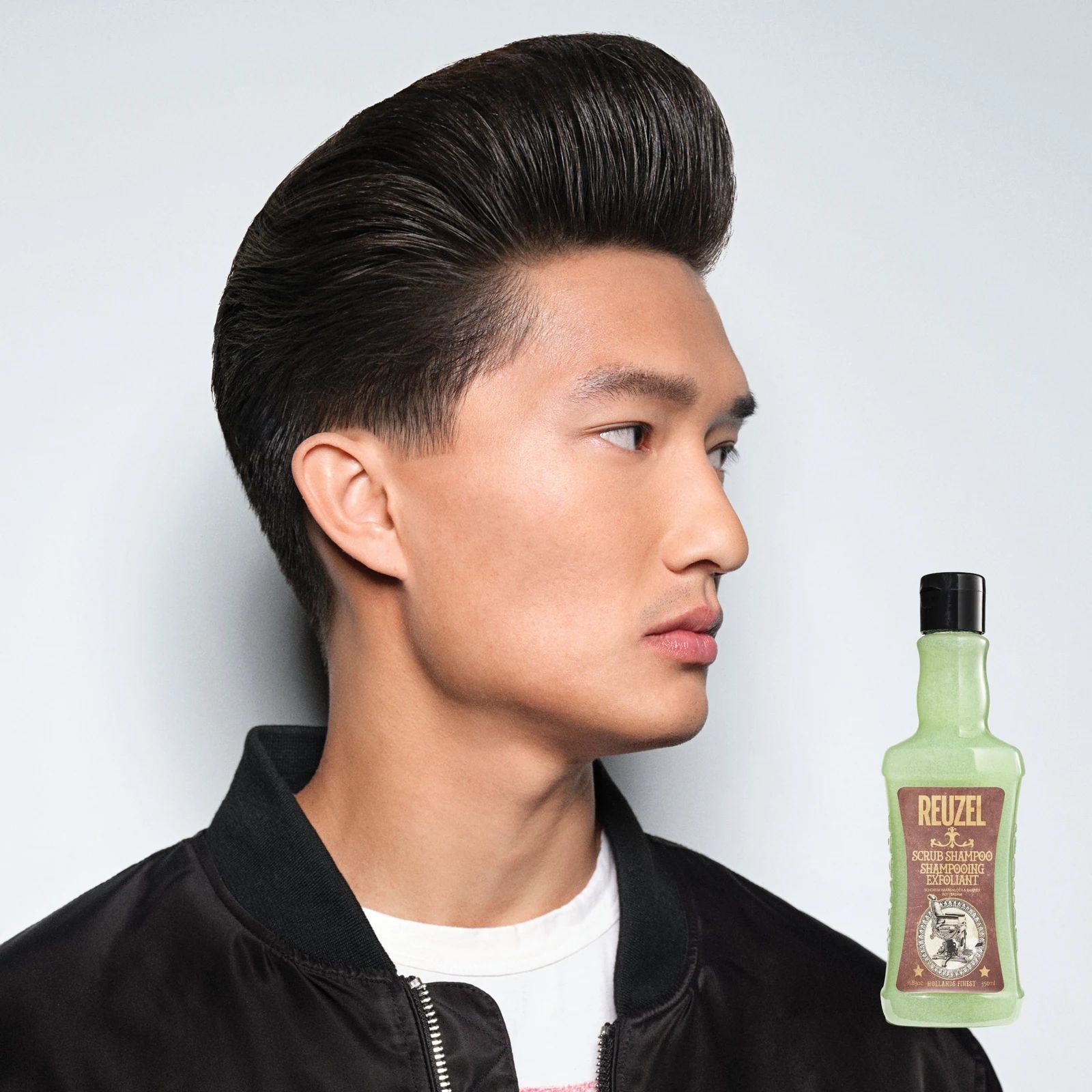 Reuzelinc Scrub Shampoo bottle with textured label, showcasing its brand and product details on a clean background.