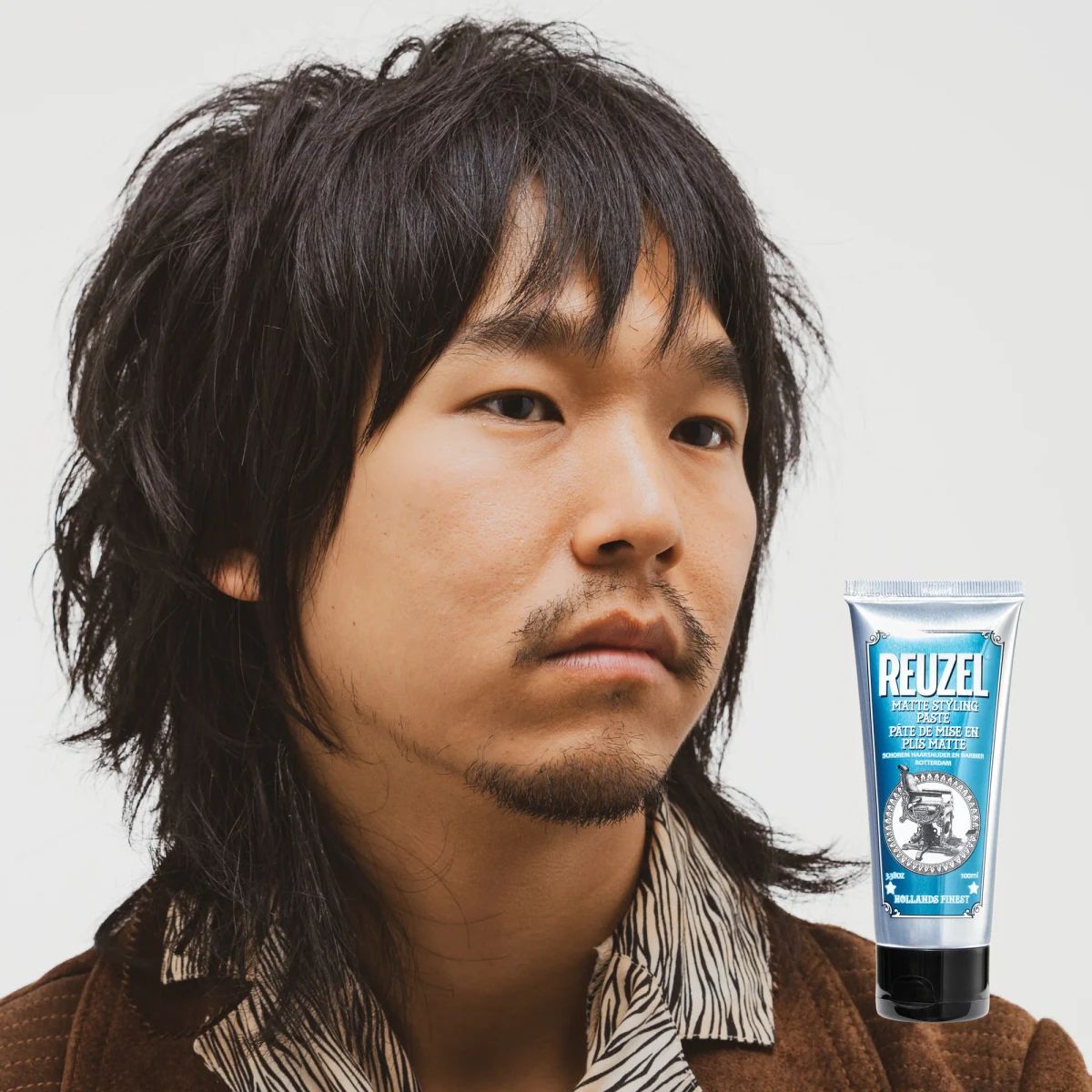 Piecey mid length black hair with a matte finish beside Reuzel Matte Styling Paste